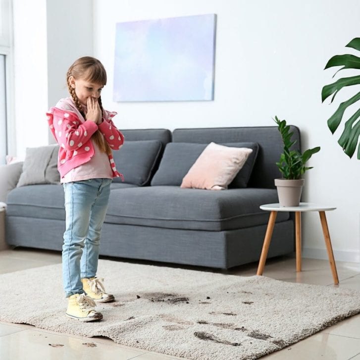 girl in muddy shoes messing up carpet at home