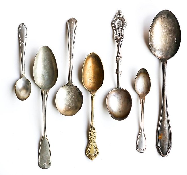 set of antique silver spoons on white background