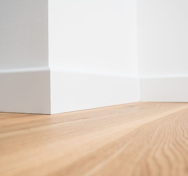 wooden floor with white walls and baseboards