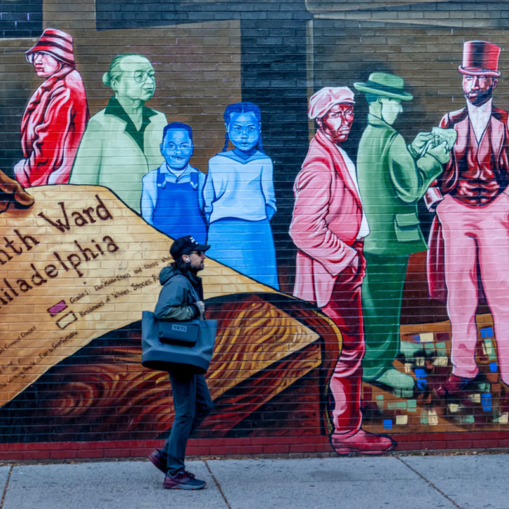 Man Walking by Mapping Courage Mural in Philadelphia