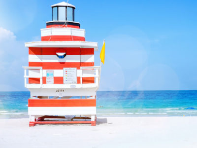 red and white beach lifeguard hut with a yellow flag