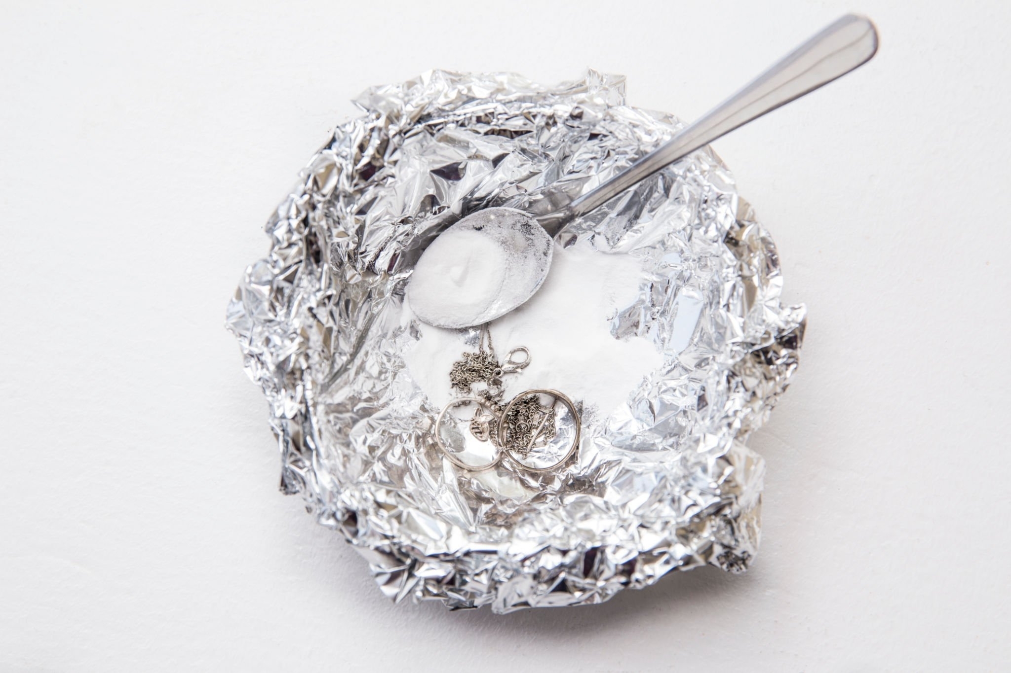A solution of baking soda and warm water will remove the tarnish from silver