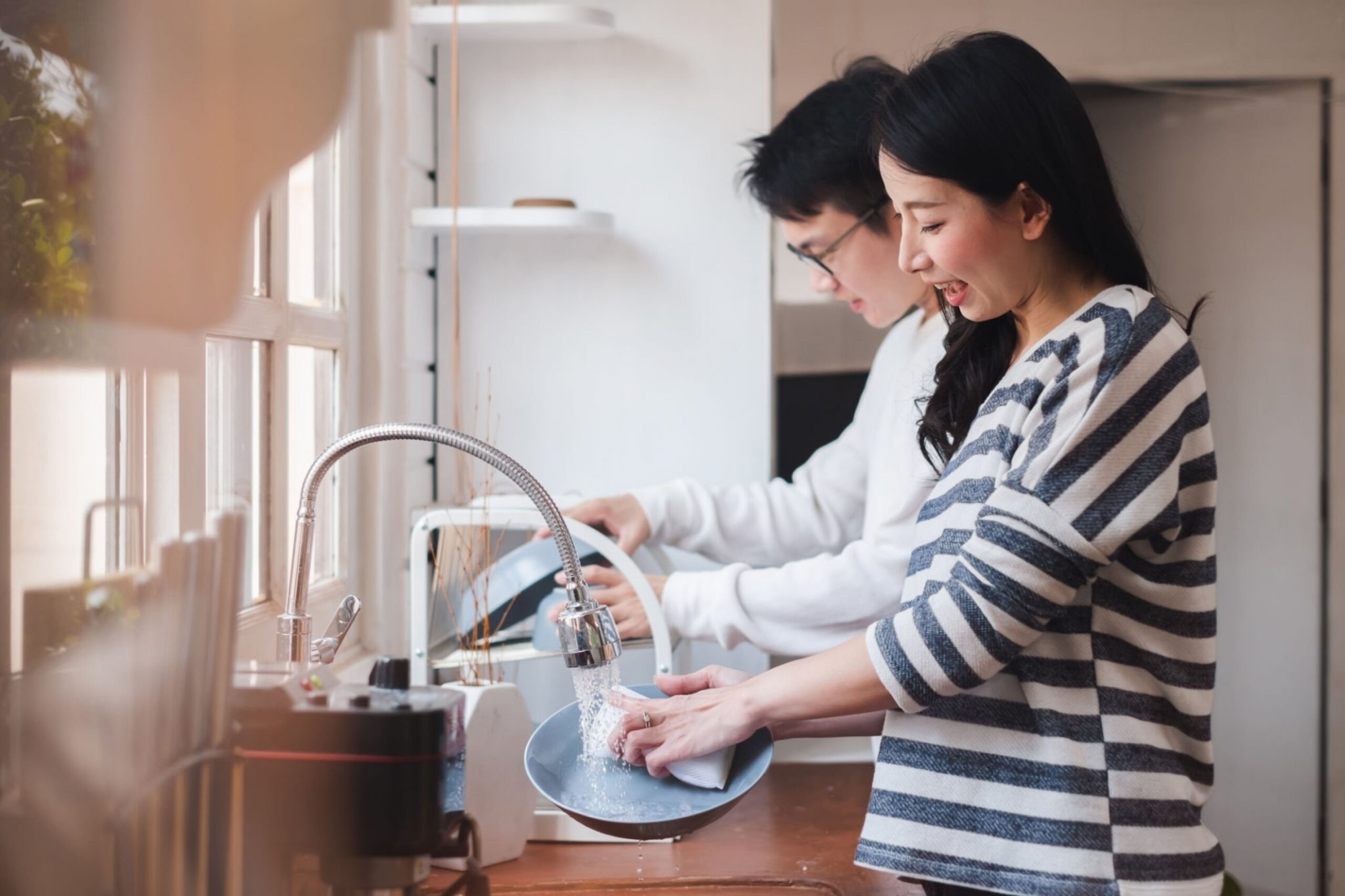 Asian couple family washing dishes together at kitchen