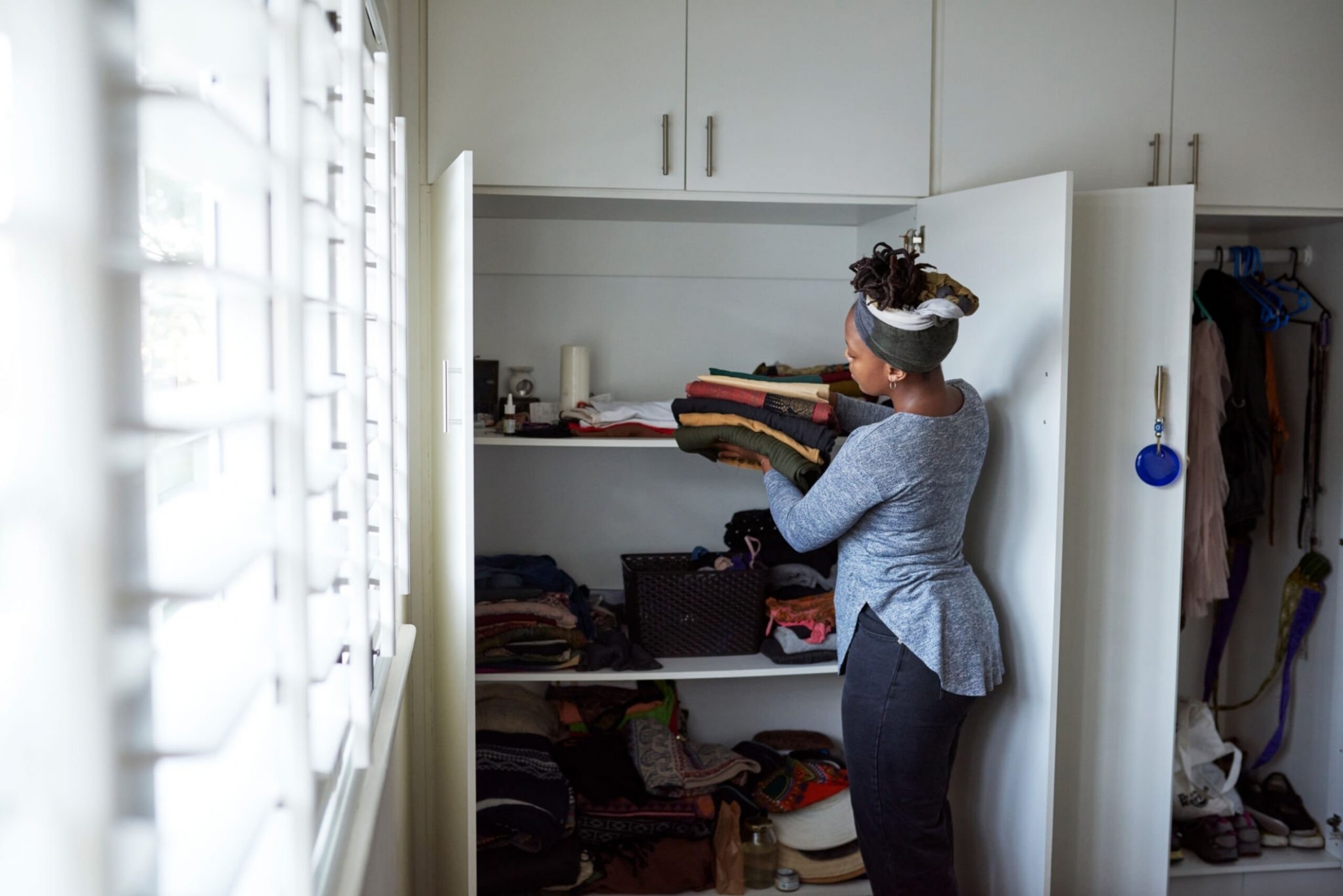 woman packing away clean laundry at home