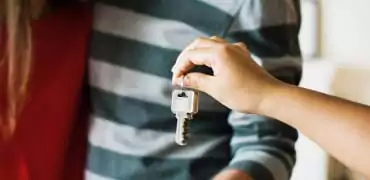 Hand of a woman handing home keys