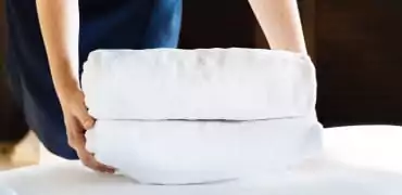 Folded towels placed on top of the bed