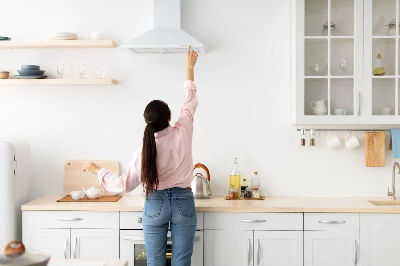 woman turning on the range hood