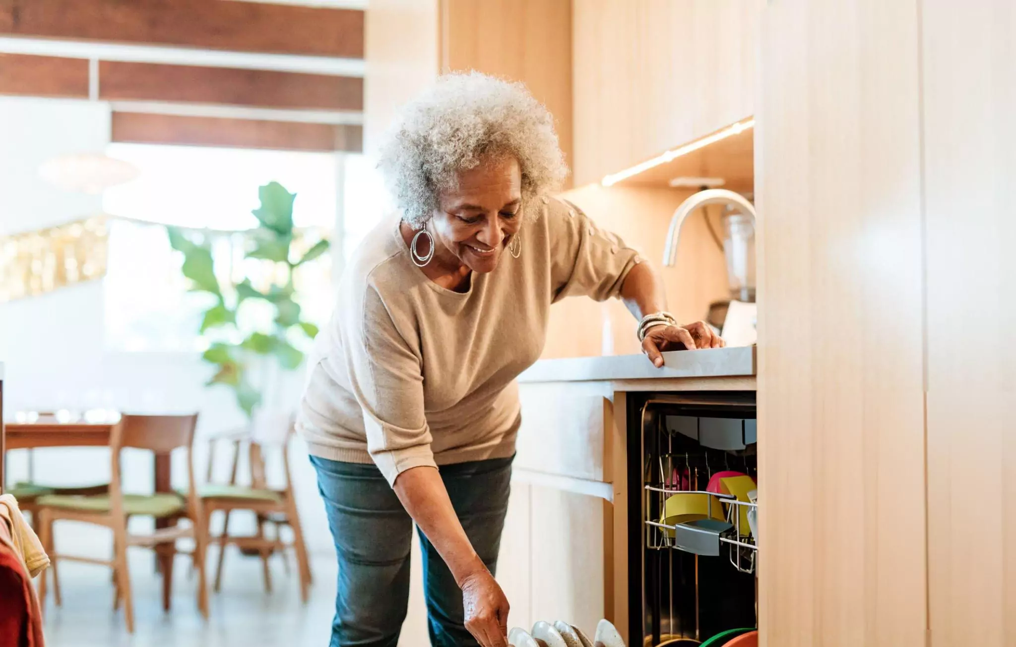 Clean Home Habits Clenzen Image of a Senior Woman Keeping Plates in Dishwasher