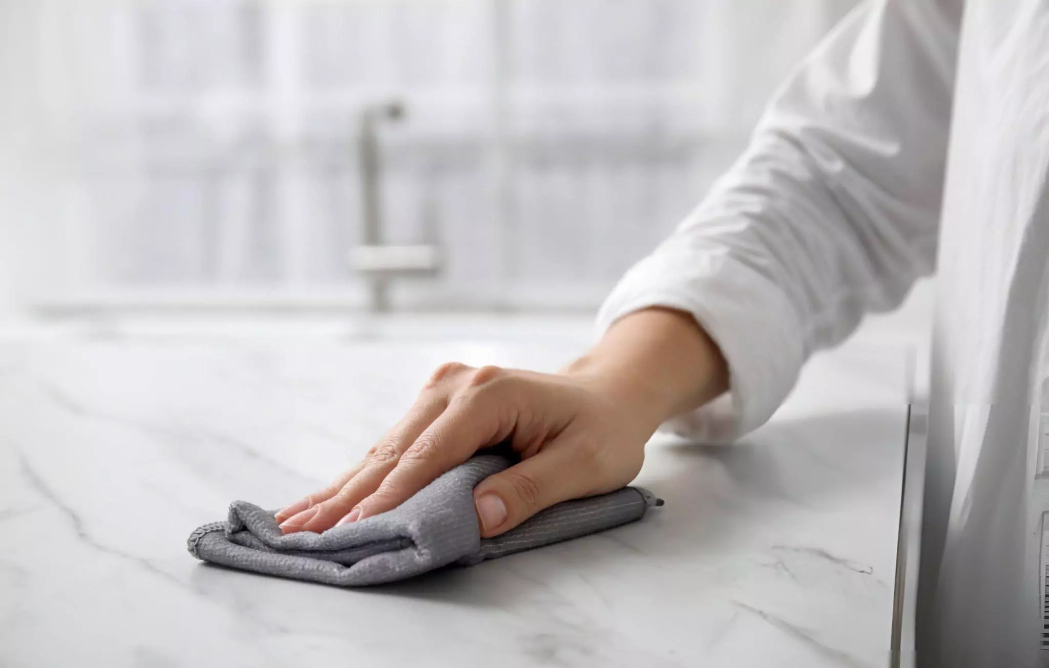 How to Clean Quartz Countertops Cleanzen Image of a Woman Wiping Counters