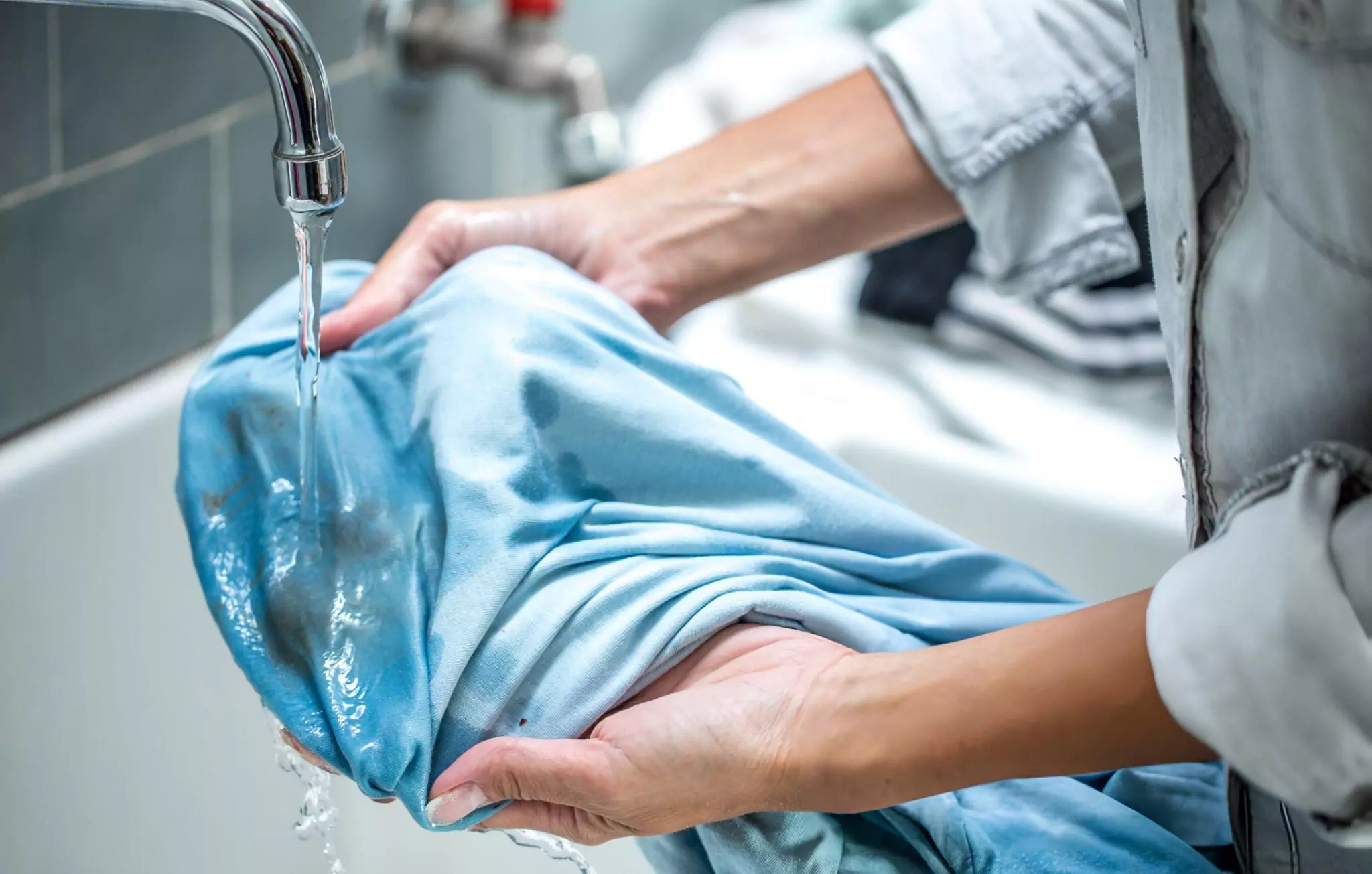 Oxygen Bleach Cleanzen Image of a Woman Cleaning Stained Shirt in Bathroom Sink