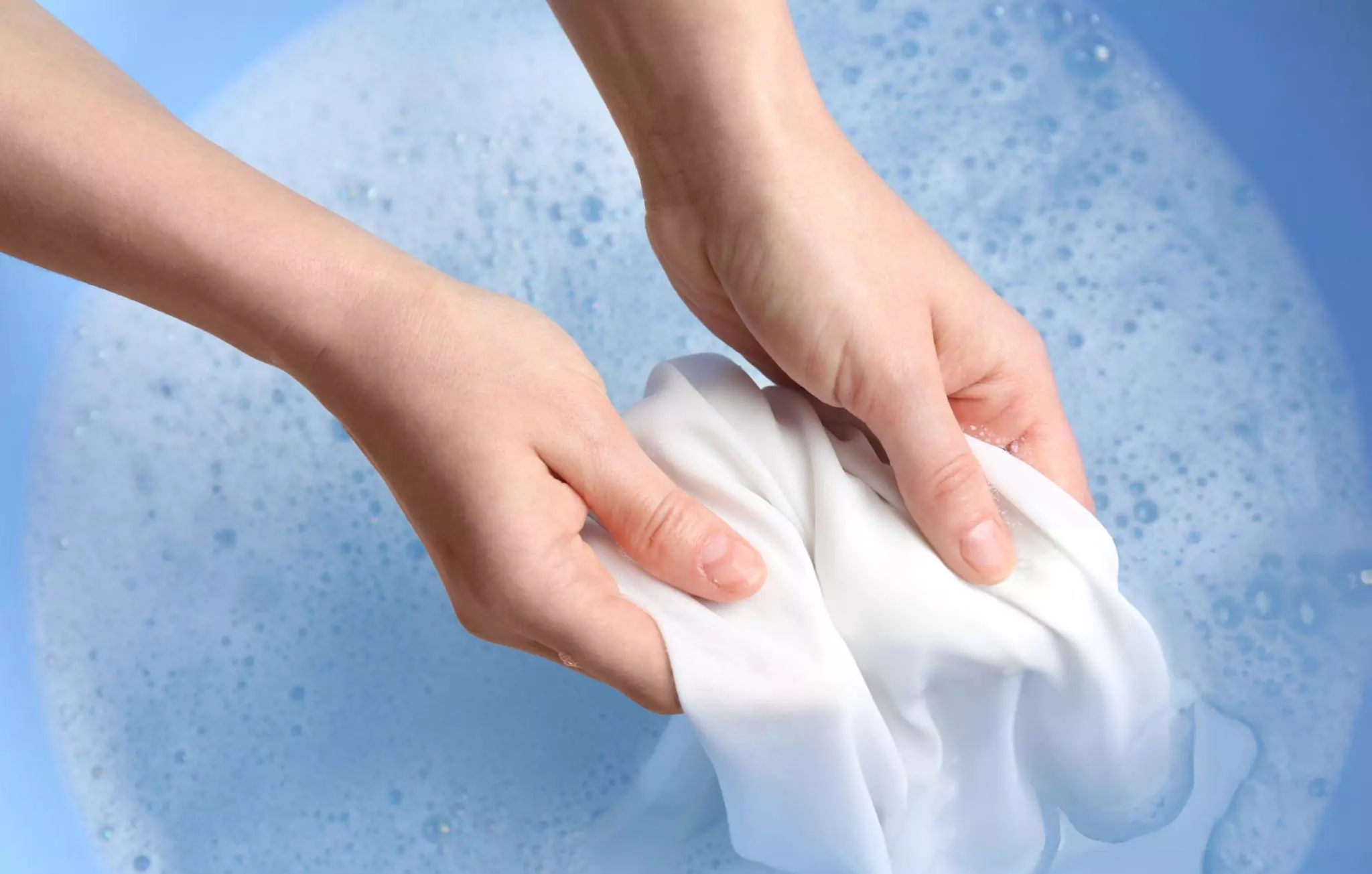 Bleach Alternative Cleanzen Top View of a Woman Hand Washing White Clothing in Suds