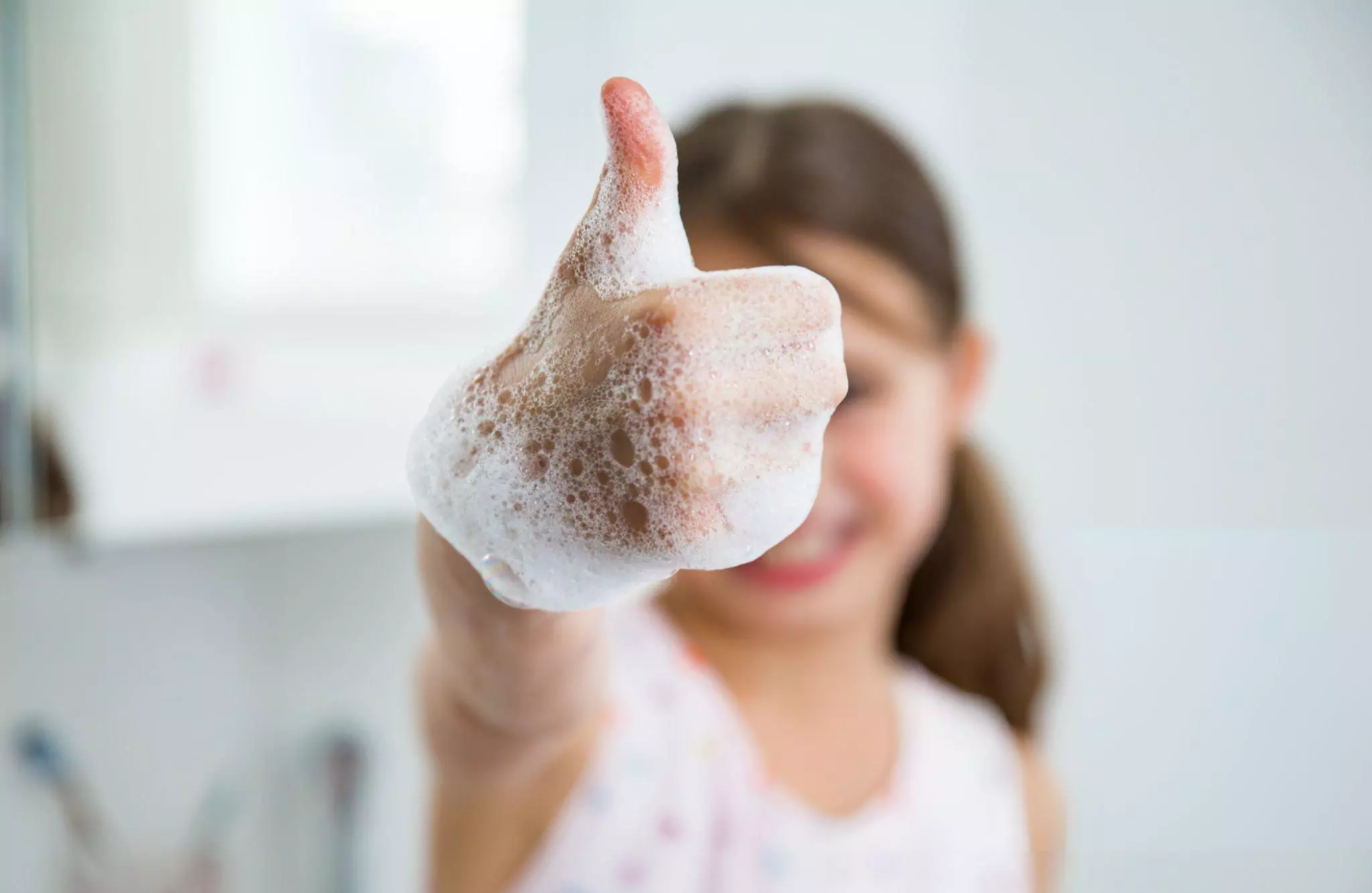 How to Make Foaming Hand Soap Cleanzen Image of a Little girl washing hands with water and soap in bathroom