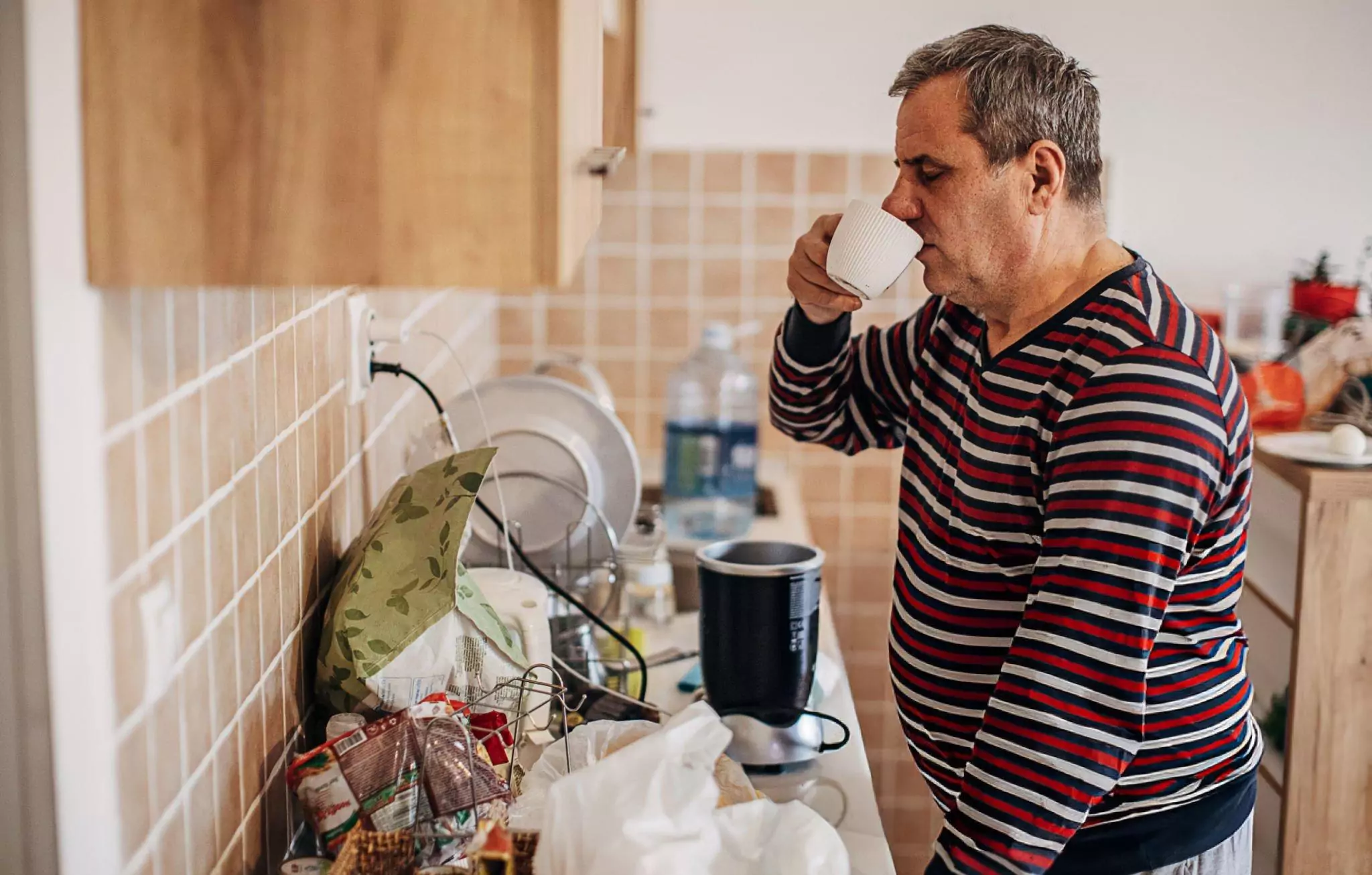 Ways to Help Make Cleaning Easier for Seniors Cleanzen Image of a Senior Man in a Cluttered Kitchen