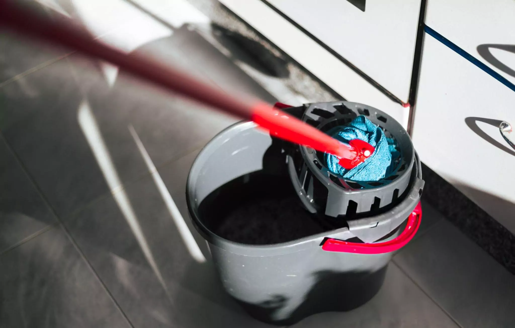 Mopping the Floor Cleanzen Image of a Mop and Cleaning Bucket on the Kitchen