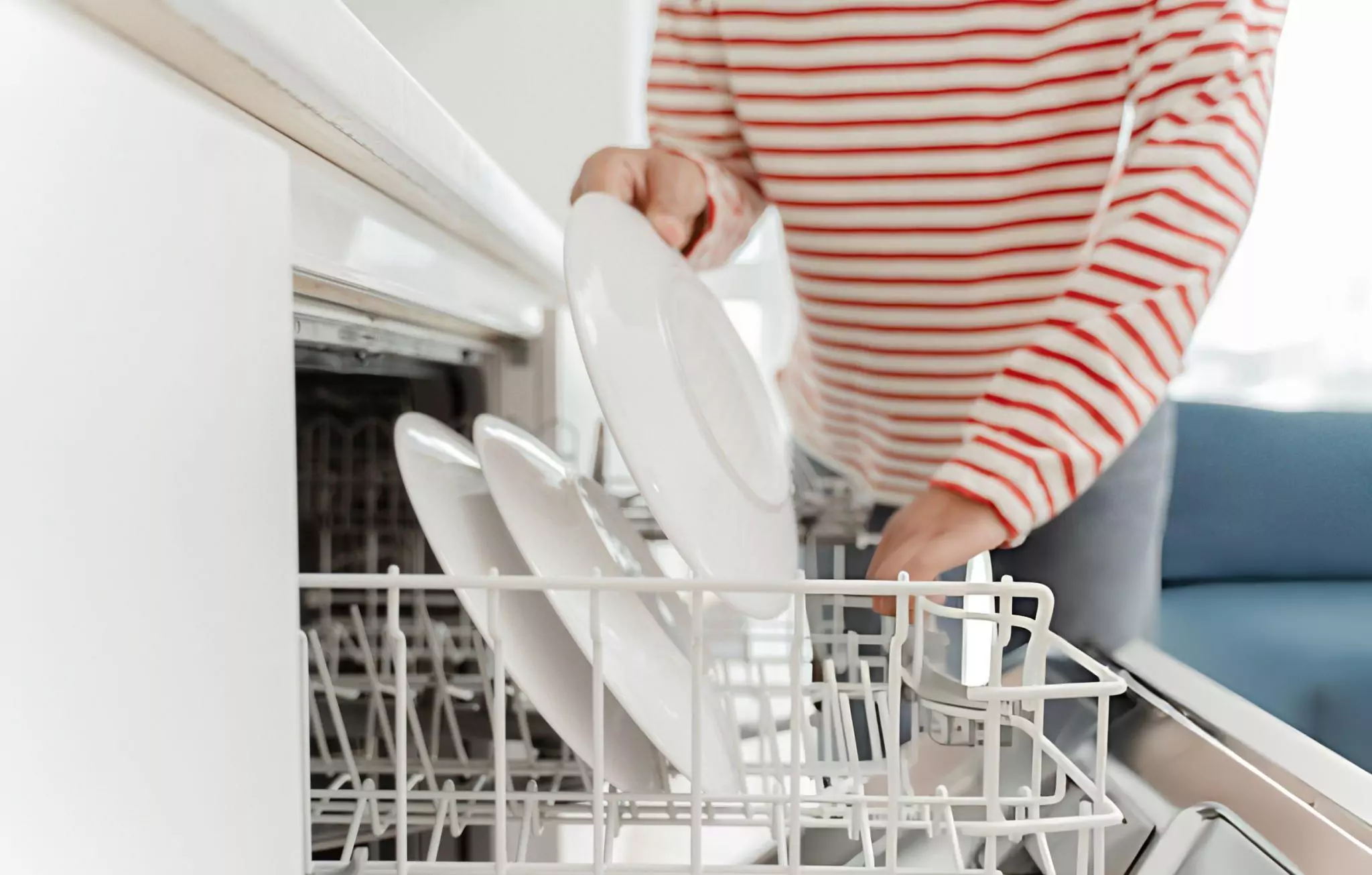 Most Overlooked Places to Clean in Your Home Cleanzen Image of a Woman Loading Dishes Into Dishwasher