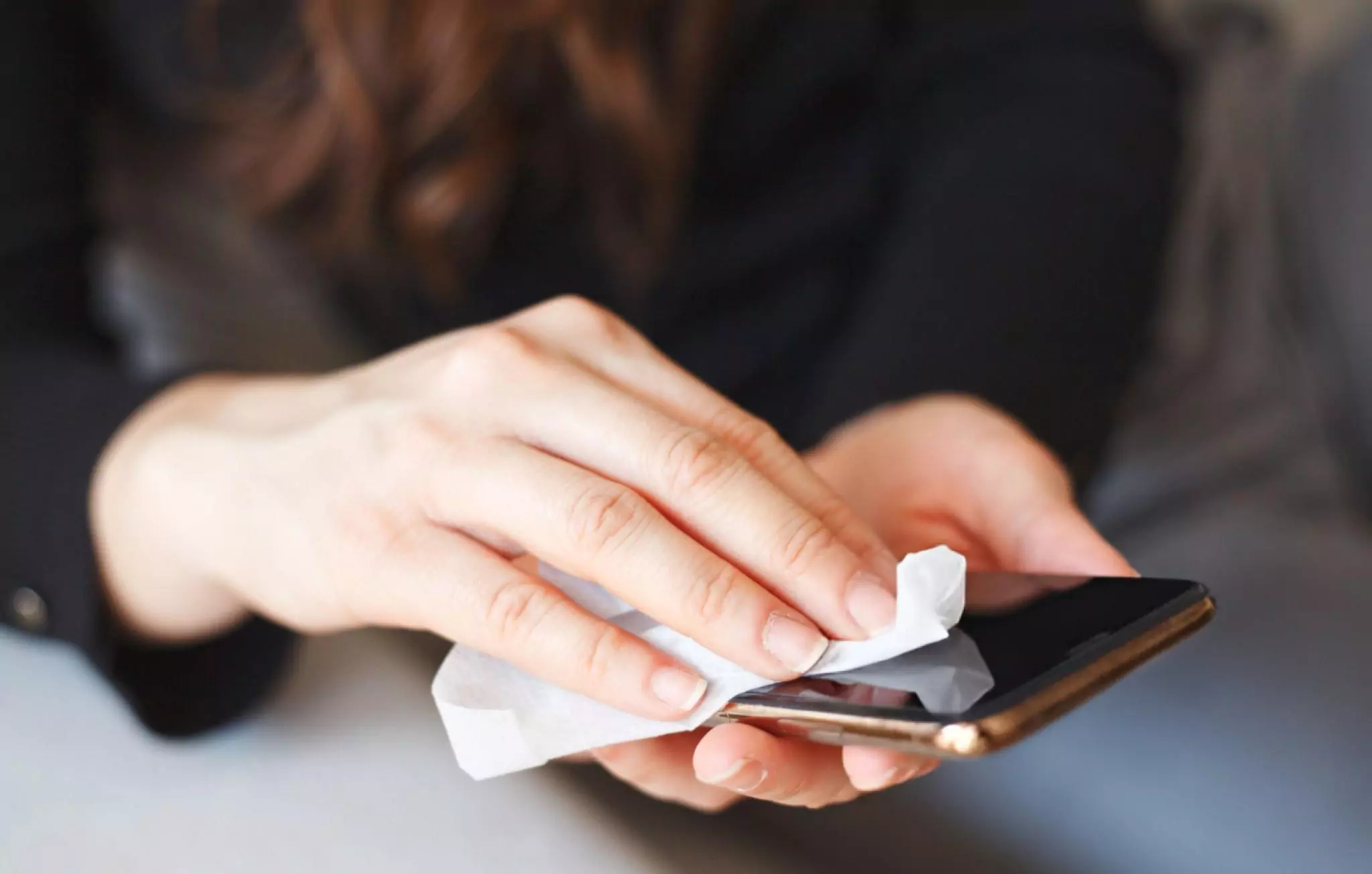 Things You Should Never Clean with Vinegar Cleanzen Image of a Woman Hand Wiping Down Smartphone Surface