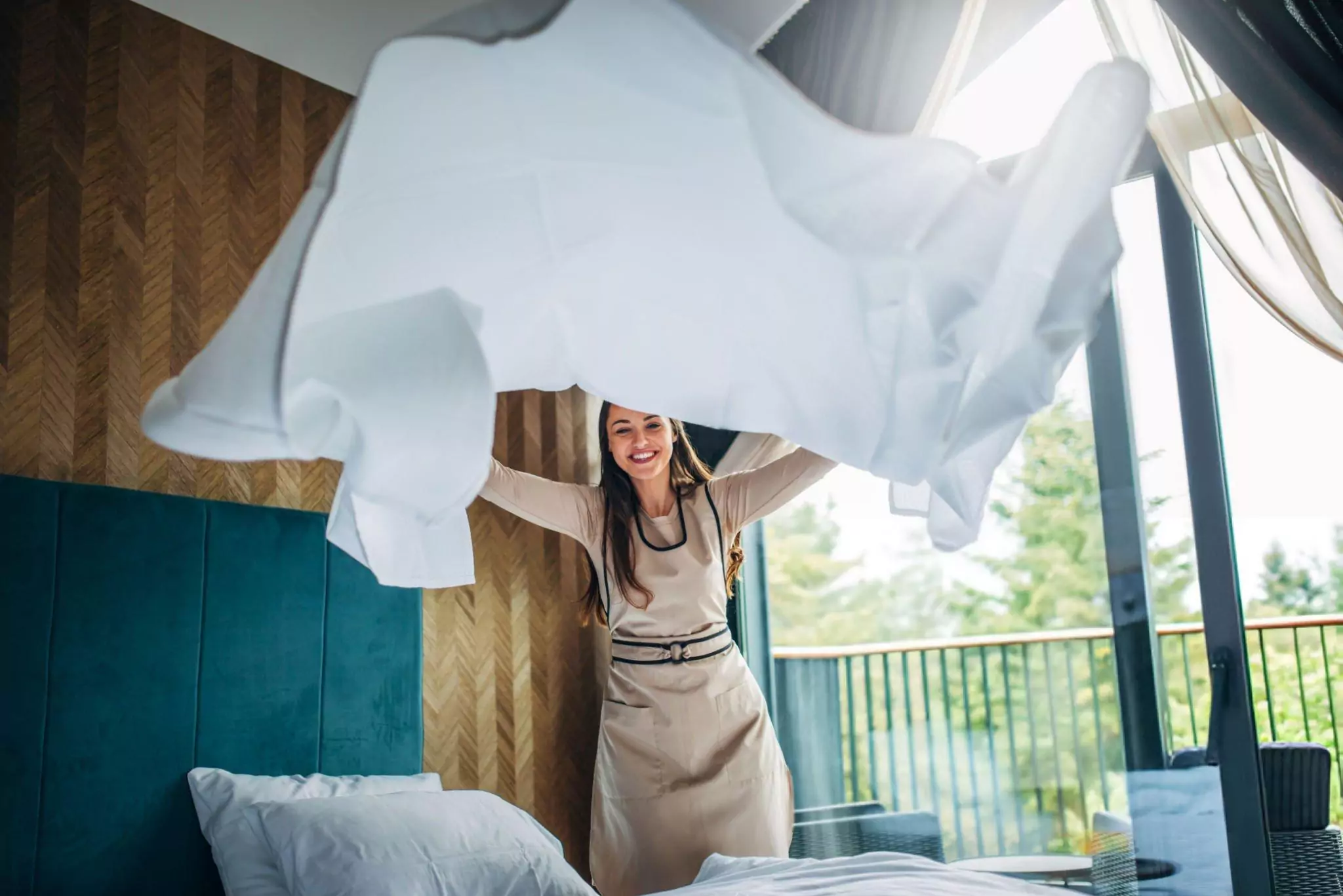 Easy Home Cleaning Resolutions for 2025 Cleanzen Image of a Young Woman Making Bed At Home